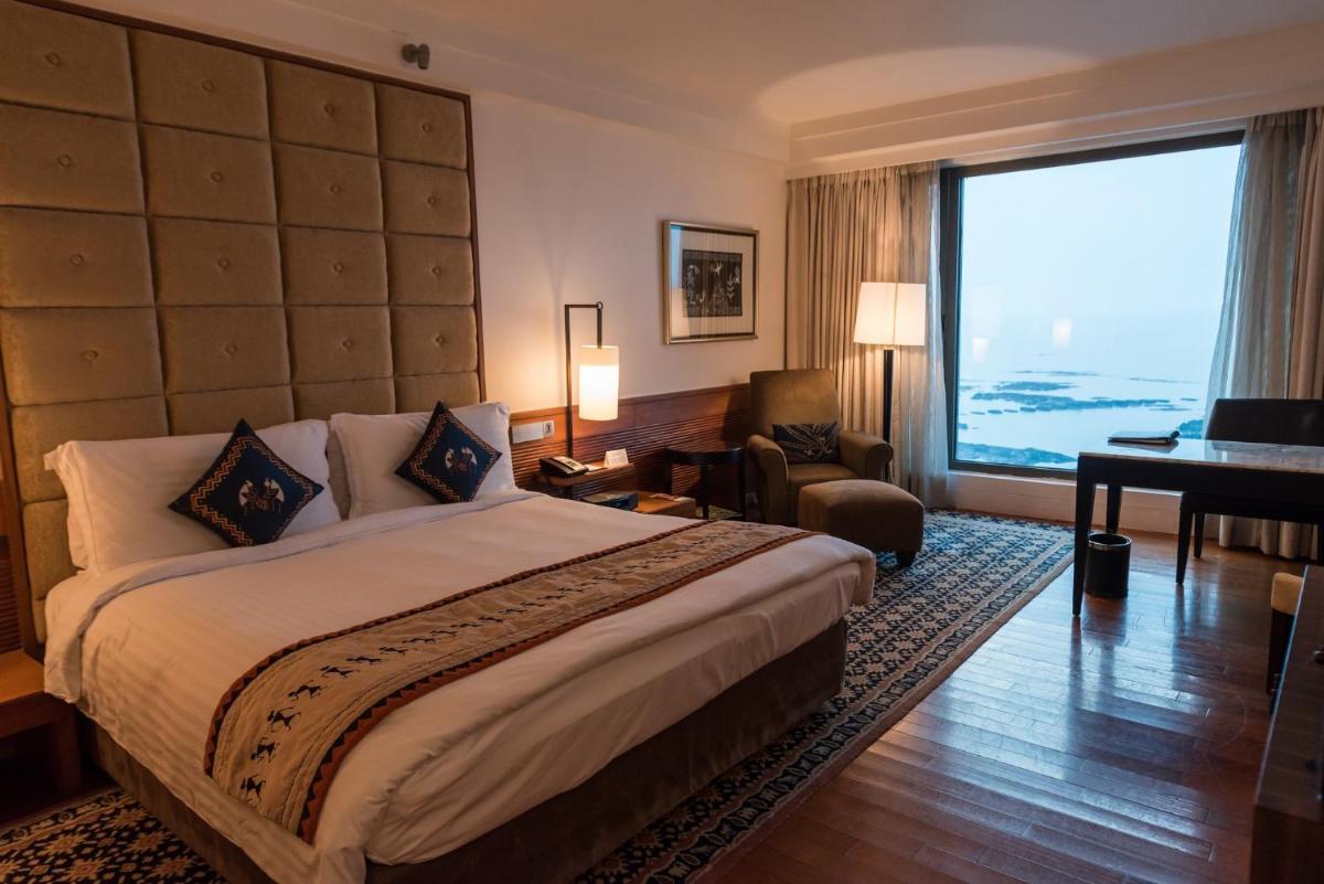 a hotel room with a bed and a large window at InterContinental Marine Drive Mumbai by IHG in Mumbai