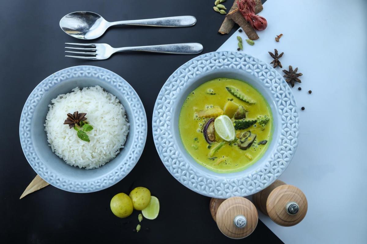 a table with a bowl of soup and rice at Radisson RED Chandigarh Mohali in Chandīgarh