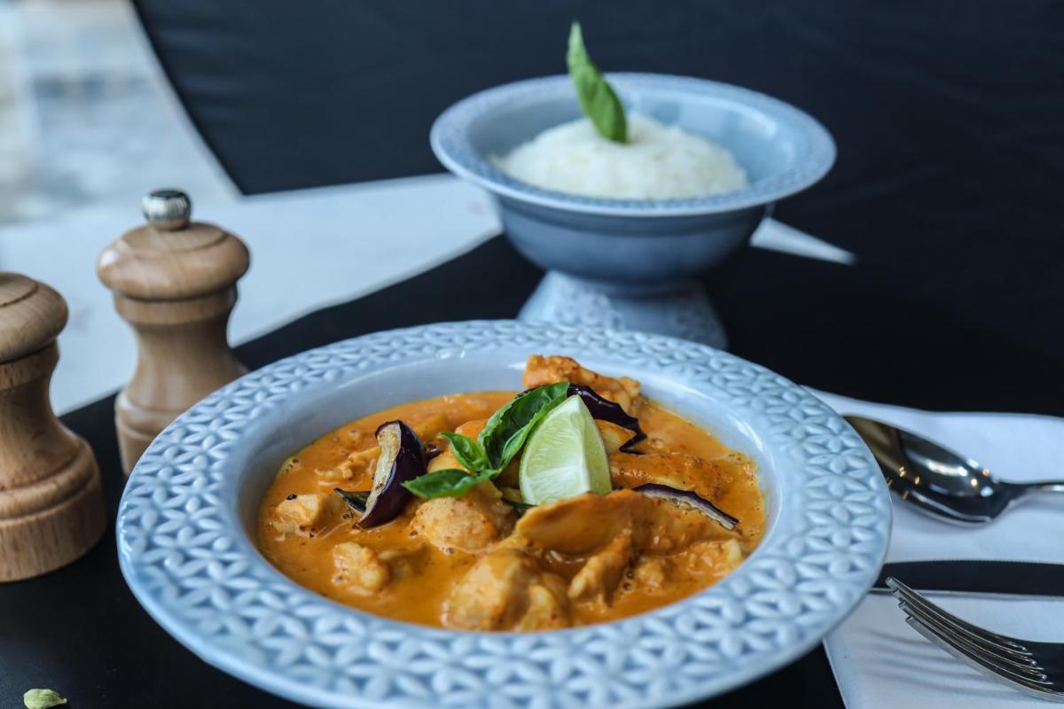 a plate of food on a table with a bowl of rice at Radisson RED Chandigarh Mohali in Chandīgarh