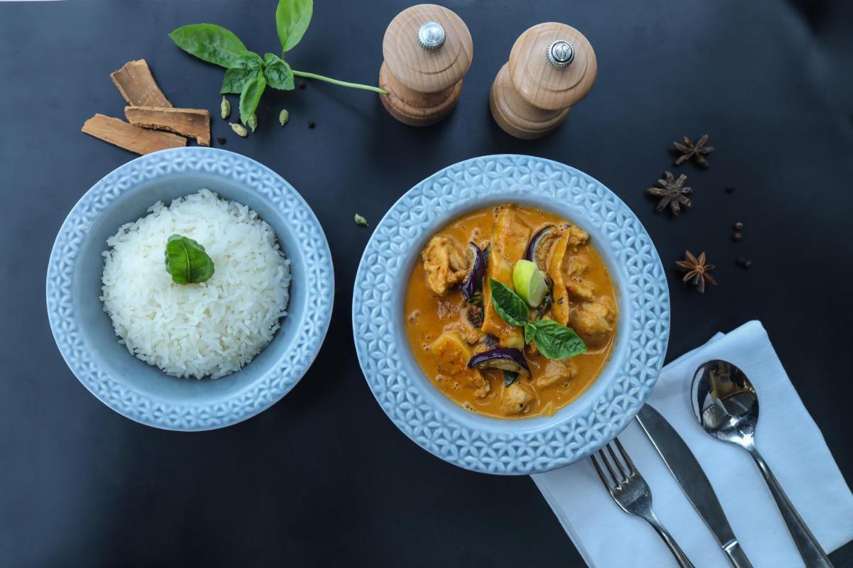 a bowl of chicken curry and rice on a table at Radisson RED Chandigarh Mohali in Chandīgarh