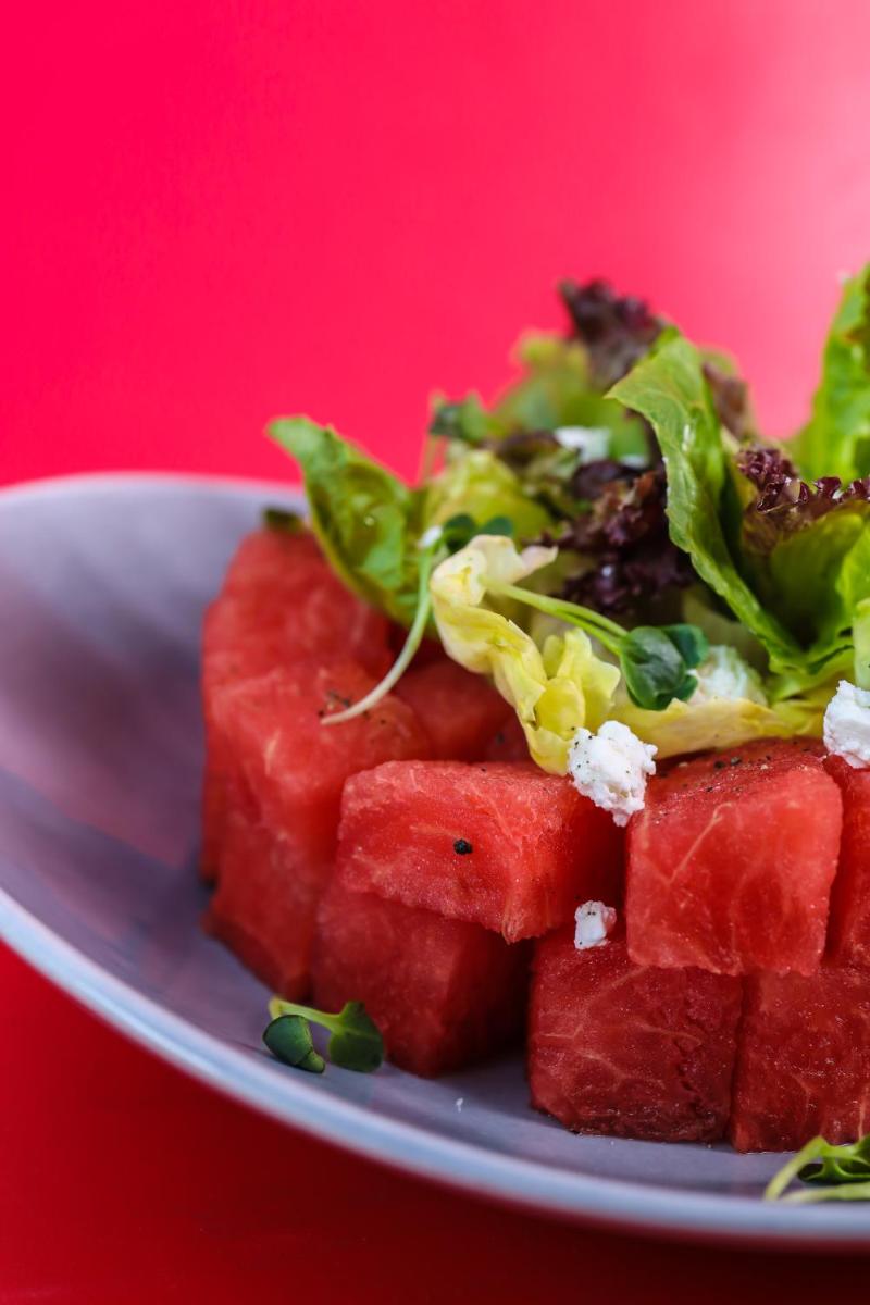 a pile of watermelon on a plate with a salad at Radisson RED Chandigarh Mohali in Chandīgarh