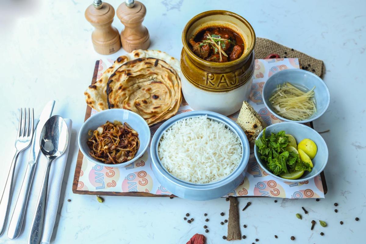 a table topped with bowls of rice and other foods at Radisson RED Chandigarh Mohali in Chandīgarh