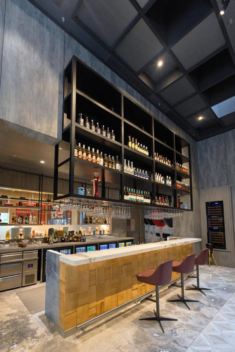 a bar with two chairs and a counter with wine glasses at Radisson RED Chandigarh Mohali in Chandīgarh