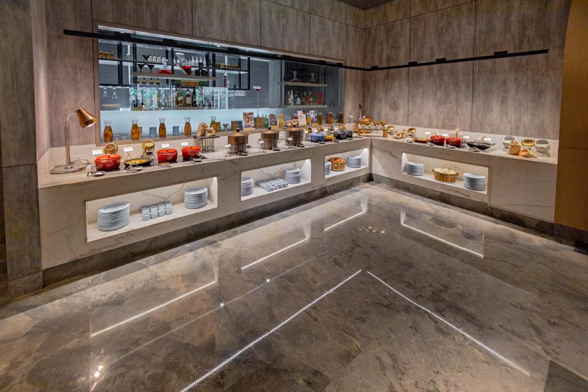a restaurant with a counter with food on it at Radisson RED Chandigarh Mohali in Chandīgarh