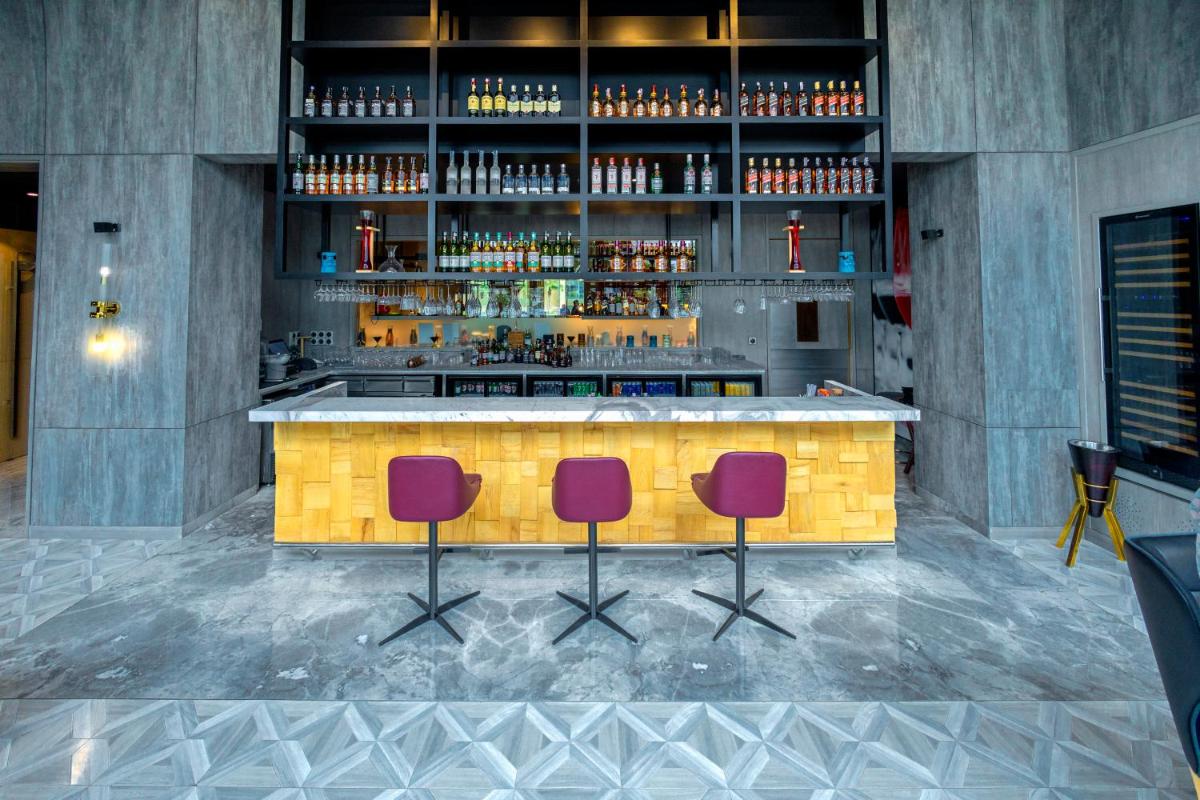 a bar with two chairs and a counter with drinks at Radisson RED Chandigarh Mohali in Chandīgarh