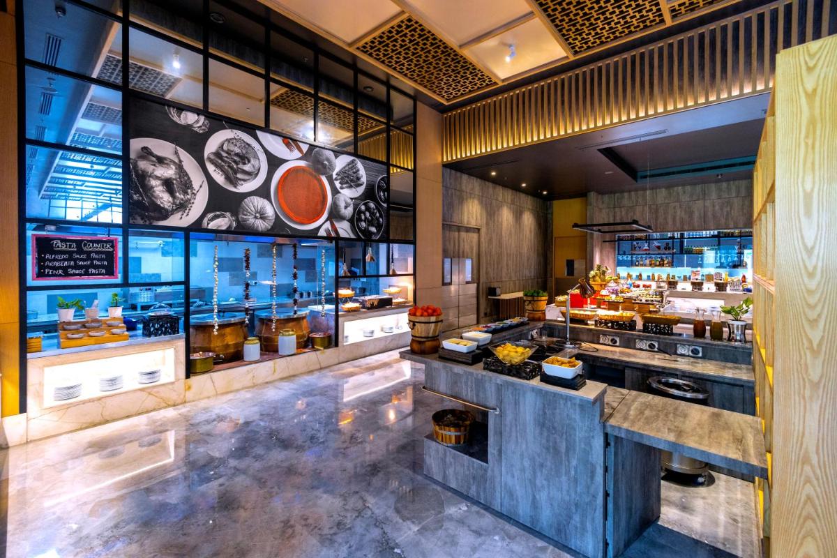 a restaurant with a counter with food on it at Radisson RED Chandigarh Mohali in Chandīgarh