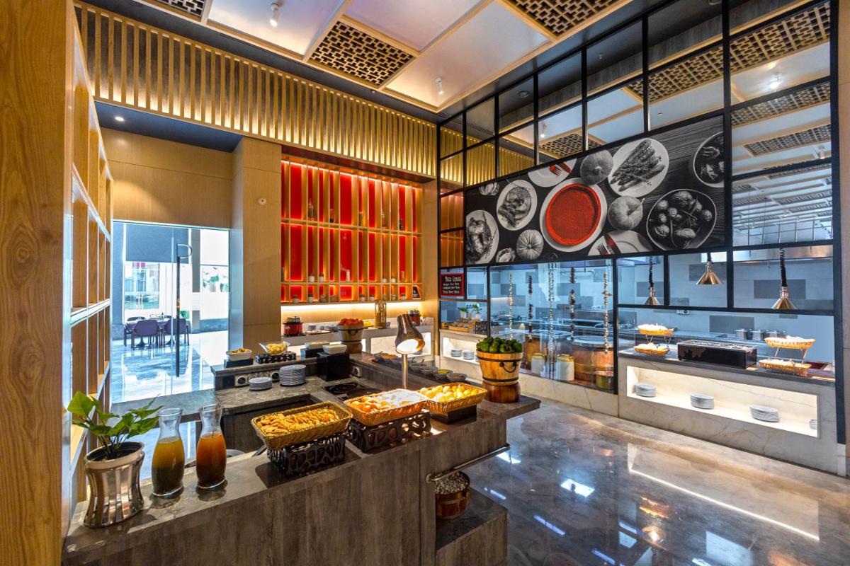a restaurant with a counter with food on display at Radisson RED Chandigarh Mohali in Chandīgarh