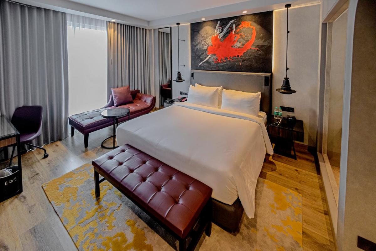 a bedroom with a large bed and a couch at Radisson RED Chandigarh Mohali in Chandīgarh