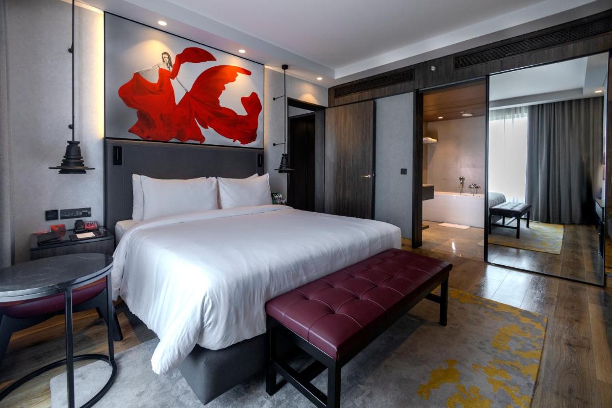 a bedroom with a large bed and a table and a desk at Radisson RED Chandigarh Mohali in Chandīgarh