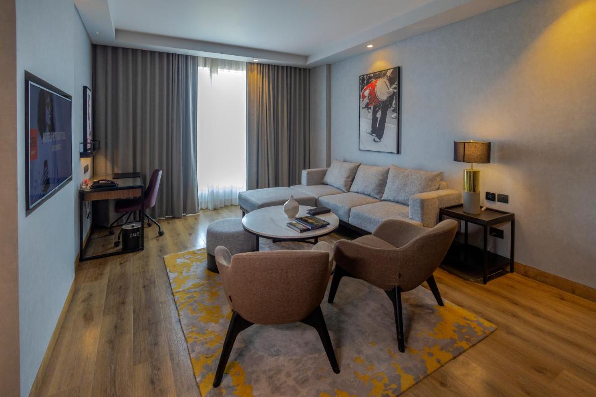 a living room with a couch and a table and chairs at Radisson RED Chandigarh Mohali in Chandīgarh