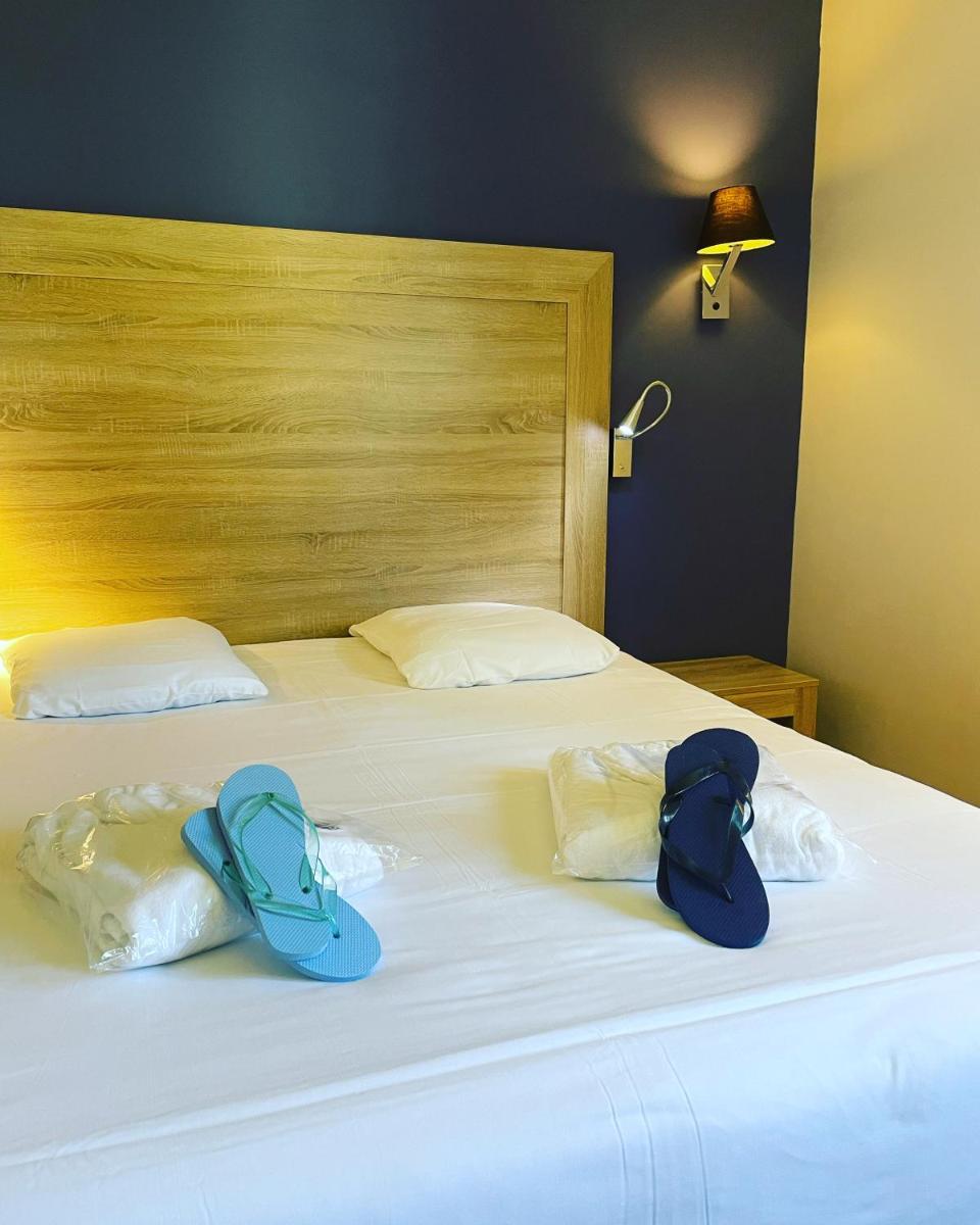 Un ou plusieurs lits dans un hébergement de l'établissement Logis Hostellerie des Clos et restaurant Bistrot des grands crus
