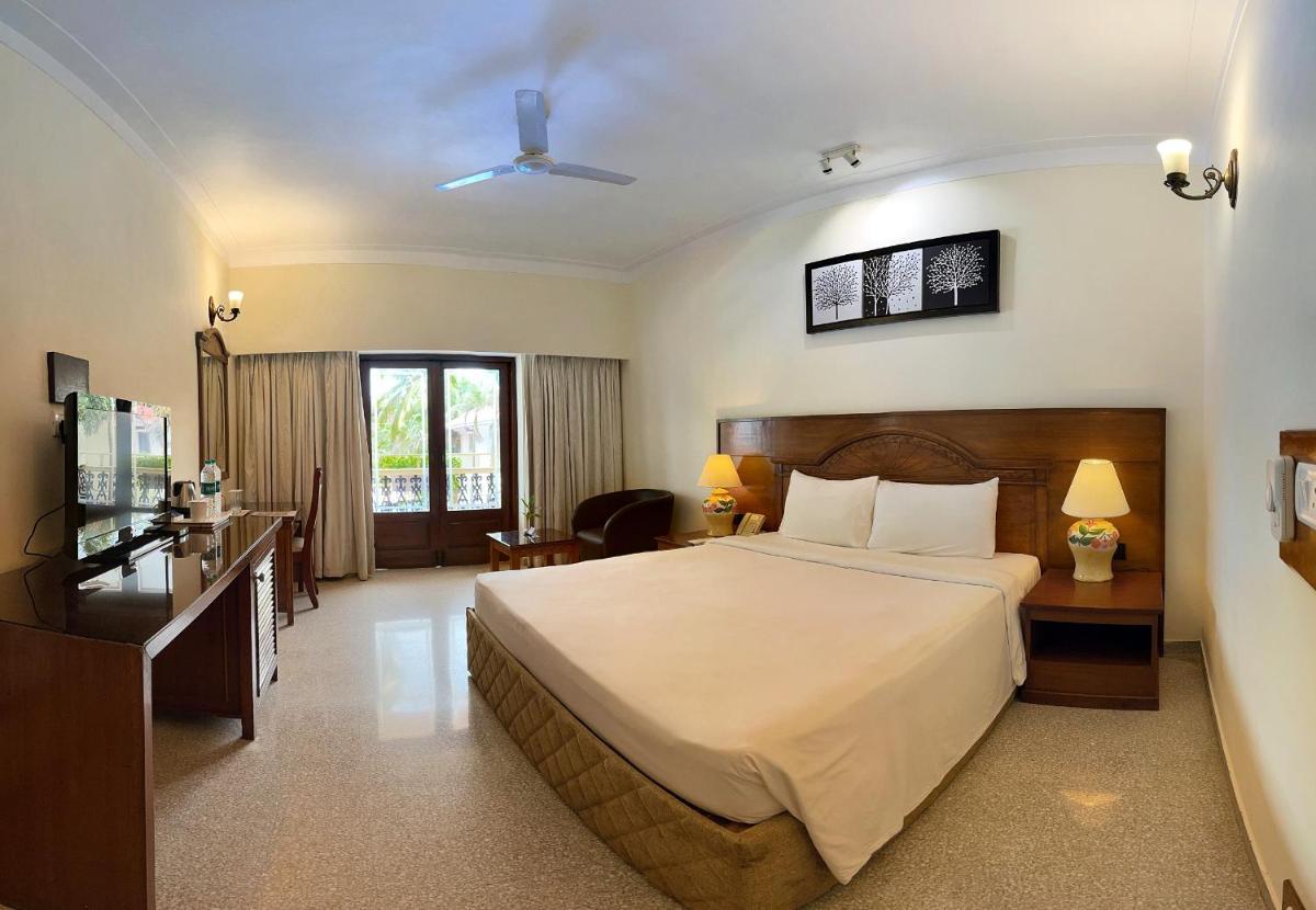 a hotel room with a bed and a desk at Radisson Goa Candolim in Candolim