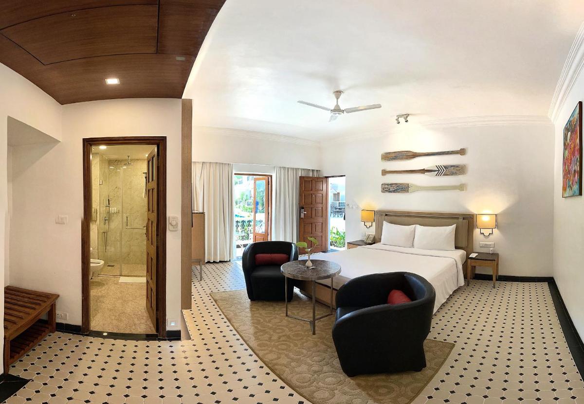 a hotel room with a bed and two chairs at Radisson Goa Candolim in Candolim