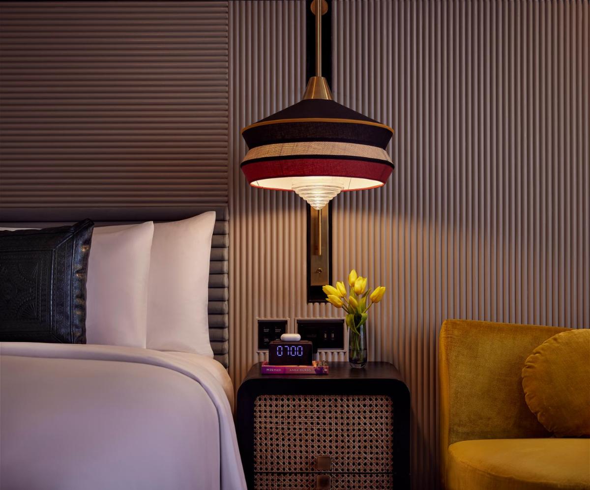 a bedroom with a bed and a lamp and a chair at Hyatt Centric Sector17 Chandigarh in Chandīgarh