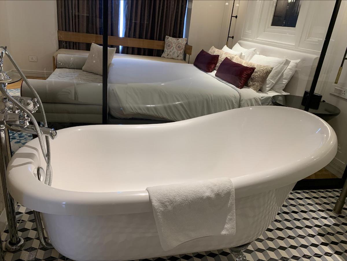 a bath tub in a room with two beds at Radisson Hotel Shimla in Shimla