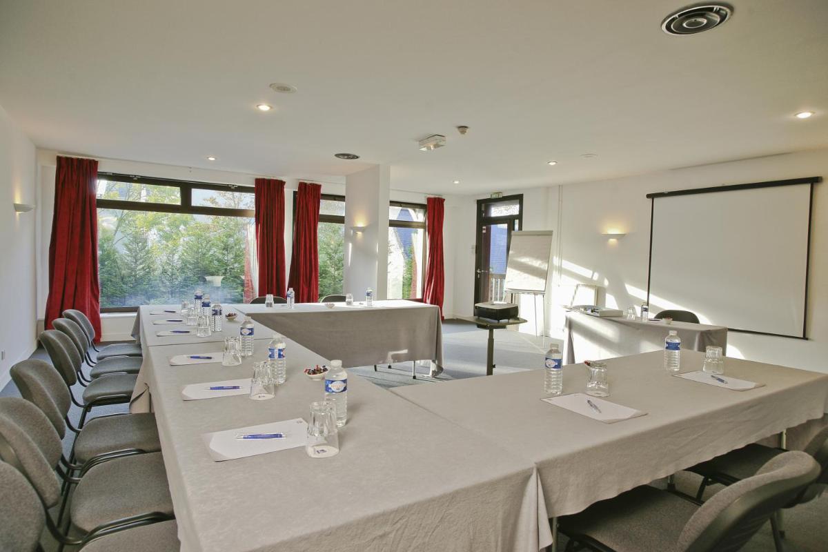 une salle de conférence avec une longue table et des chaises dans l'établissement Best Western Plus Hostellerie Du Vallon, à Trouville-sur-Mer 84 autres photos