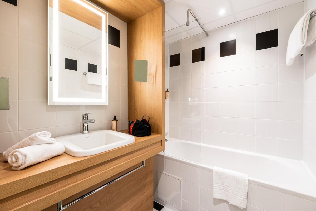 une salle de bains avec un lavabo et un miroir dans l'établissement Mercure Tours Sud, à Joué-lès-Tours