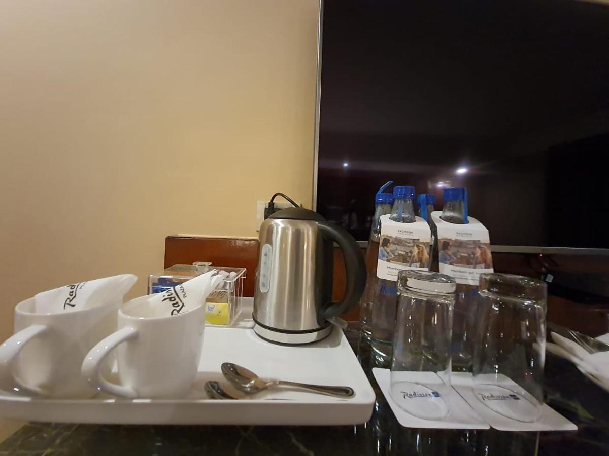 a tray with a tea kettle and cups on a table at Radisson Blu Plaza Delhi Airport in New Delhi a tray with a tea kettle and cups on a table at Radisson Blu Plaza Delhi Airport in New Delhi