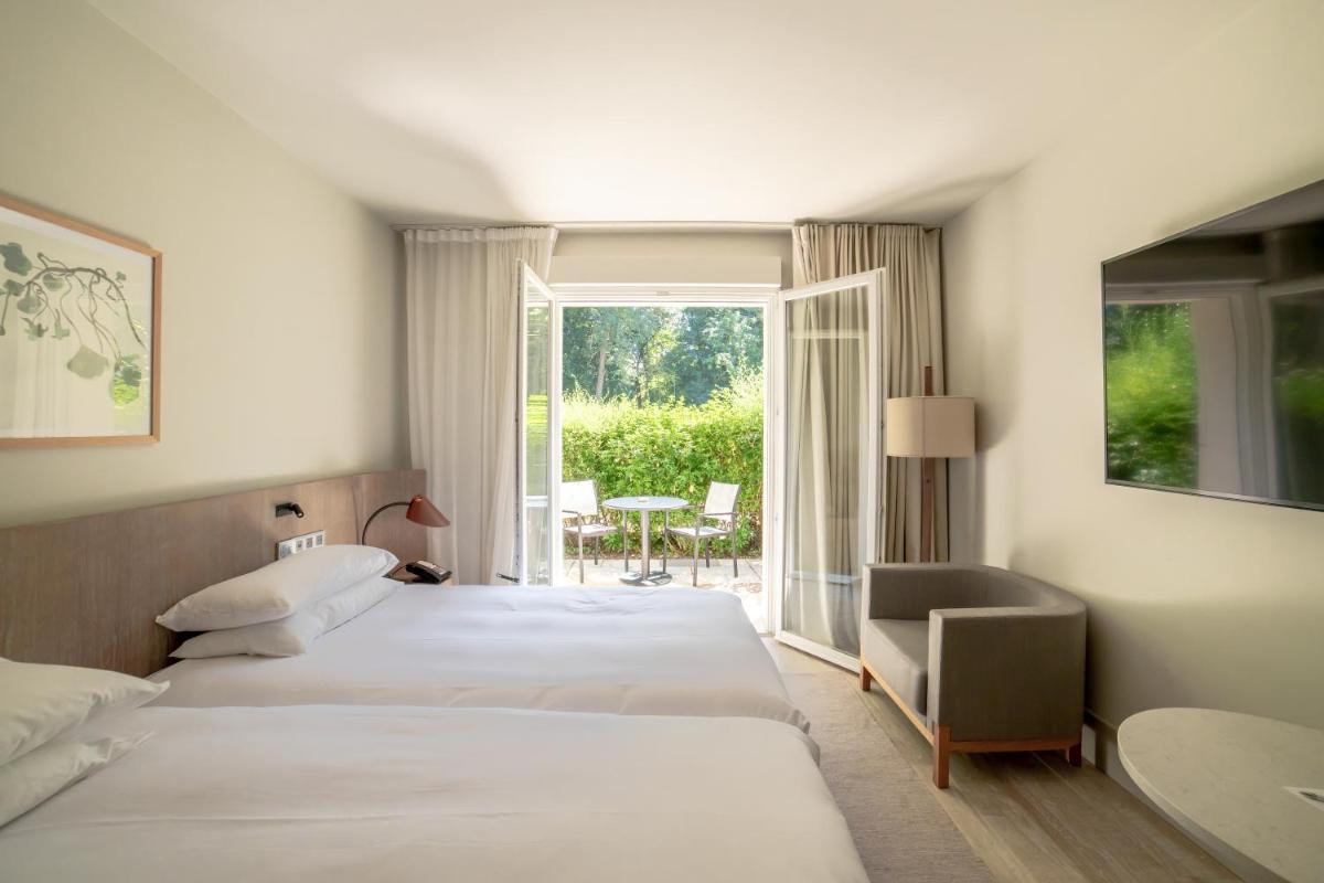 Un ou plusieurs lits dans un hébergement de l'établissement Le Grand Pavillon Chantilly