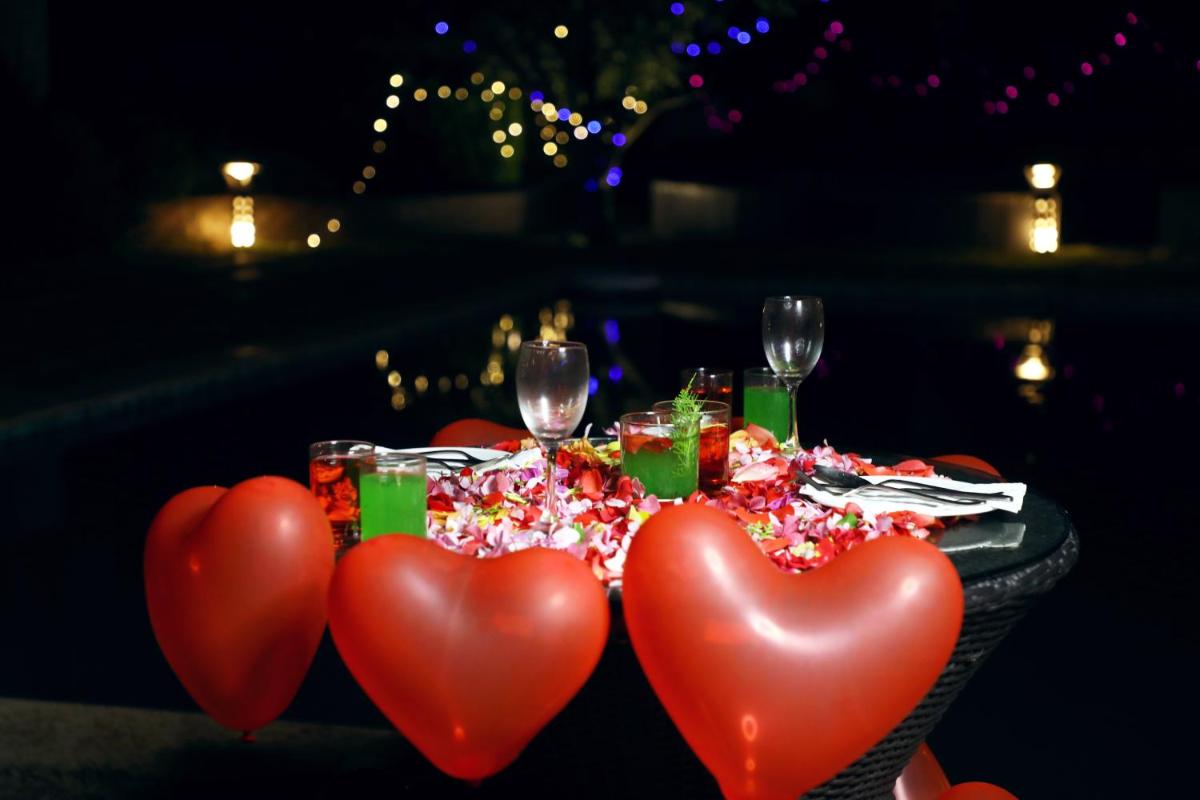 a table with three red hearts on it with wine glasses at The Orchid Manali - a Boutique Hotel in Manāli a table with three red hearts on it with wine glasses at The Orchid Manali - a Boutique Hotel in Manāli