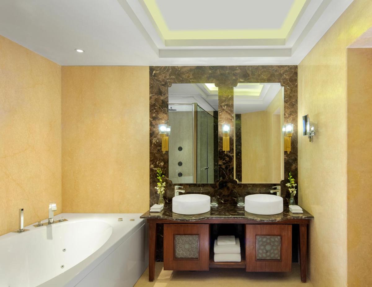 a bathroom with a tub and a large mirror at Radisson Jodhpur in Jodhpur
