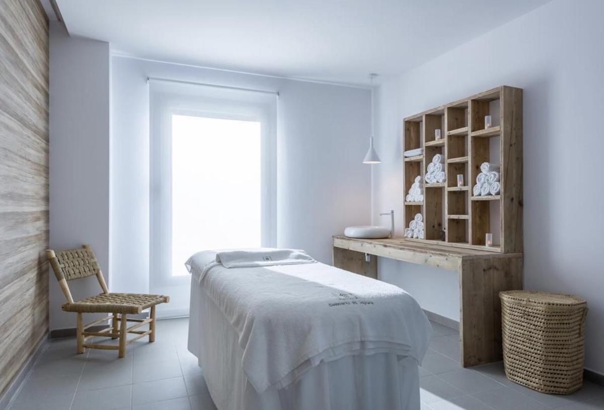 una habitación blanca con una cama y una silla en Balneario Segura de Baños, en Segura de los Baños 17 fotos más