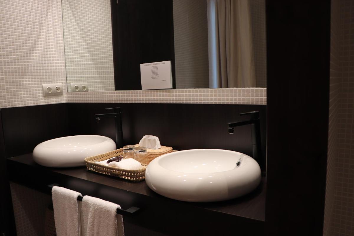 Un baño con dos lavabos y un espejo. en Balneario Segura de Baños, en Segura de los Baños
