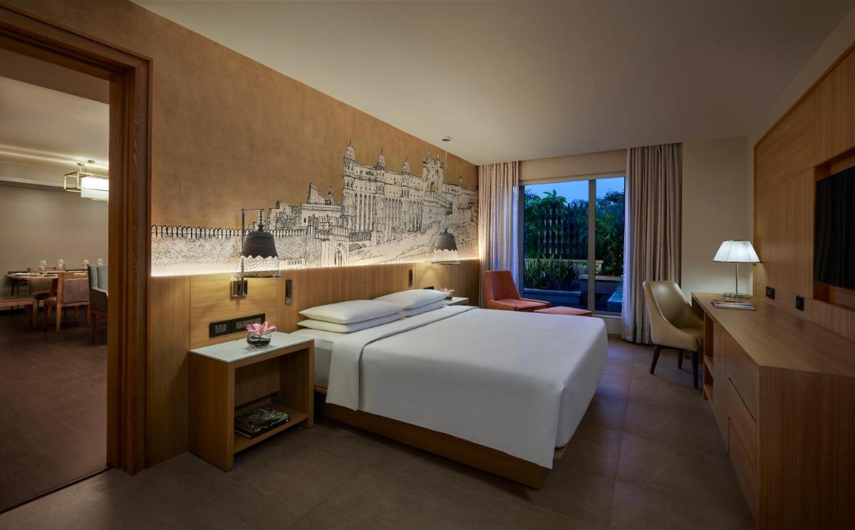 a bedroom with a large white bed and a desk at Hyatt Place Jaipur Malviya Nagar in Jaipur a bedroom with a large white bed and a desk at Hyatt Place Jaipur Malviya Nagar in Jaipur