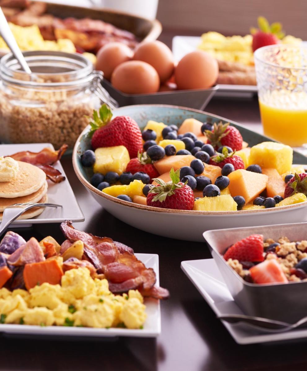 a table topped with plates of breakfast foods and eggs at Hyatt Place Jaipur Malviya Nagar in Jaipur a table topped with plates of breakfast foods and eggs at Hyatt Place Jaipur Malviya Nagar in Jaipur