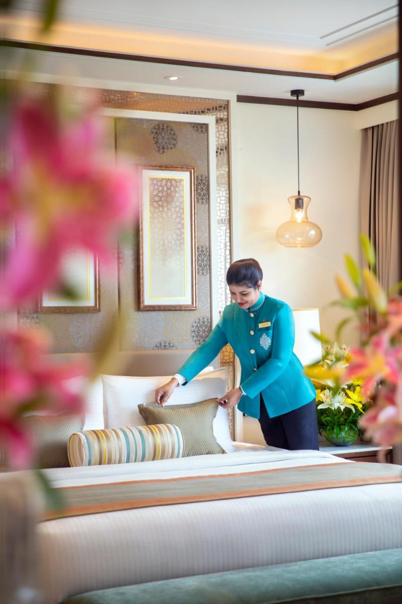 a man is making a bed in a room at Tajview, Agra-IHCL SeleQtions in Agra