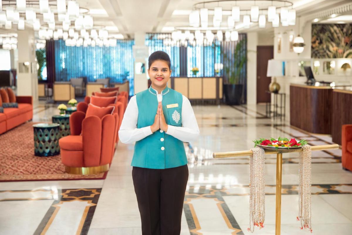 a woman is standing in a lobby with her tie at Tajview, Agra-IHCL SeleQtions in Agra