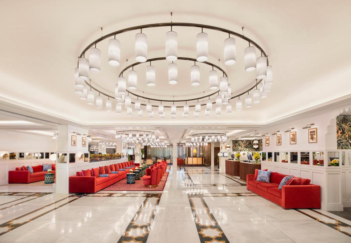 a large lobby with red chairs and a large chandelier at Tajview, Agra-IHCL SeleQtions in Agra