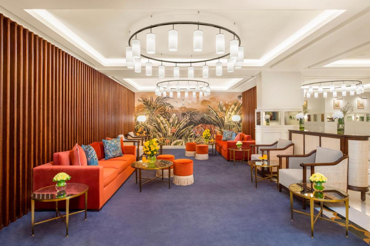 a lobby with orange furniture and a chandelier at Tajview, Agra-IHCL SeleQtions in Agra