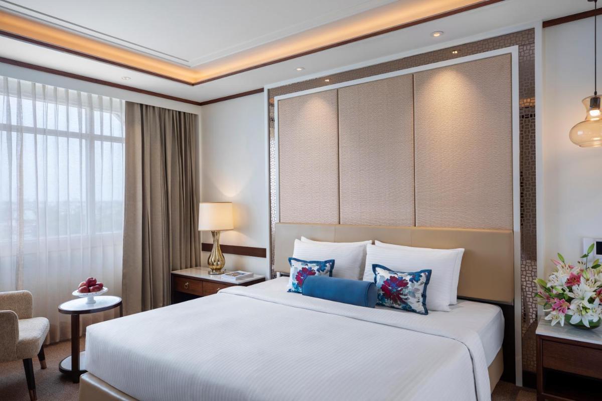 a hotel room with a large bed and a chair at Tajview, Agra-IHCL SeleQtions in Agra