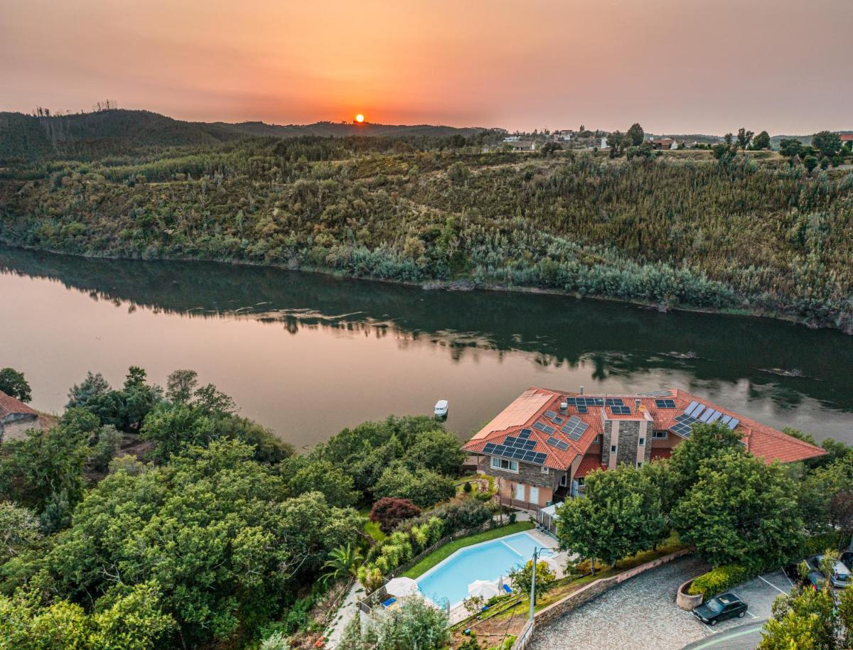 uma vista aérea de uma casa no rio em Hotel Rural Quinta da Conchada na Aguieira