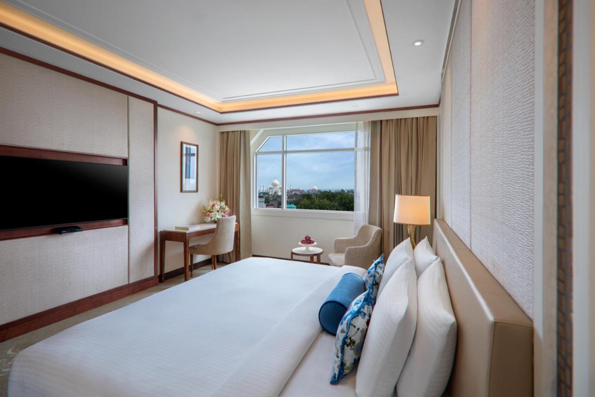 a hotel room with a bed and a large window at Tajview, Agra-IHCL SeleQtions in Agra