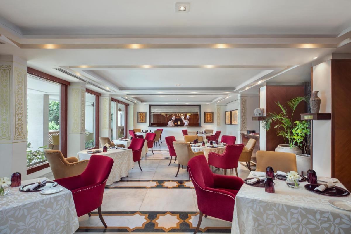 a dining room with tables and red chairs at Tajview, Agra-IHCL SeleQtions in Agra