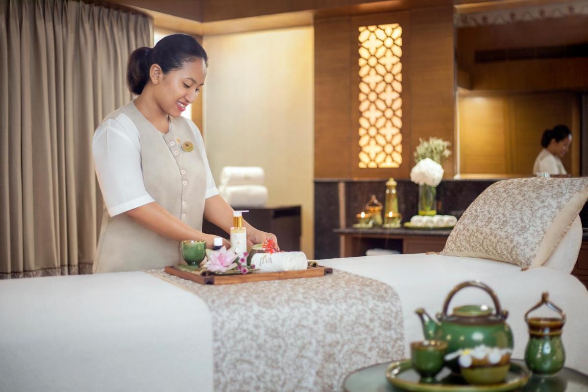 a woman standing between two beds in a hotel room at Tajview, Agra-IHCL SeleQtions in Agra