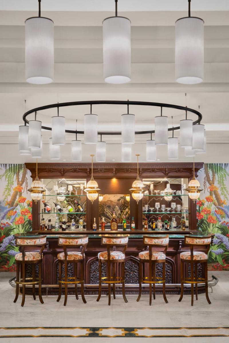 a bar with chairs and tables in front of a mural at Tajview, Agra-IHCL SeleQtions in Agra