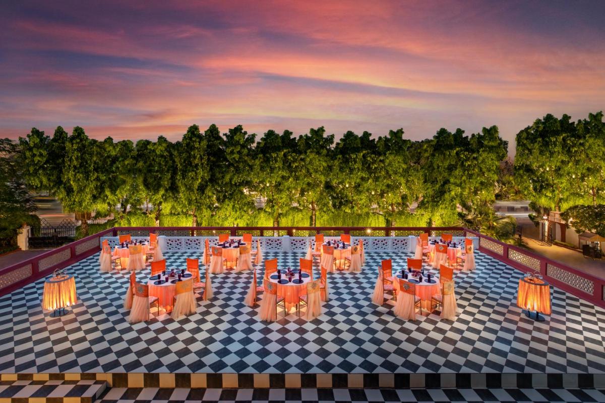 a view of a pool with orange tables and chairs at Tajview, Agra-IHCL SeleQtions in Agra