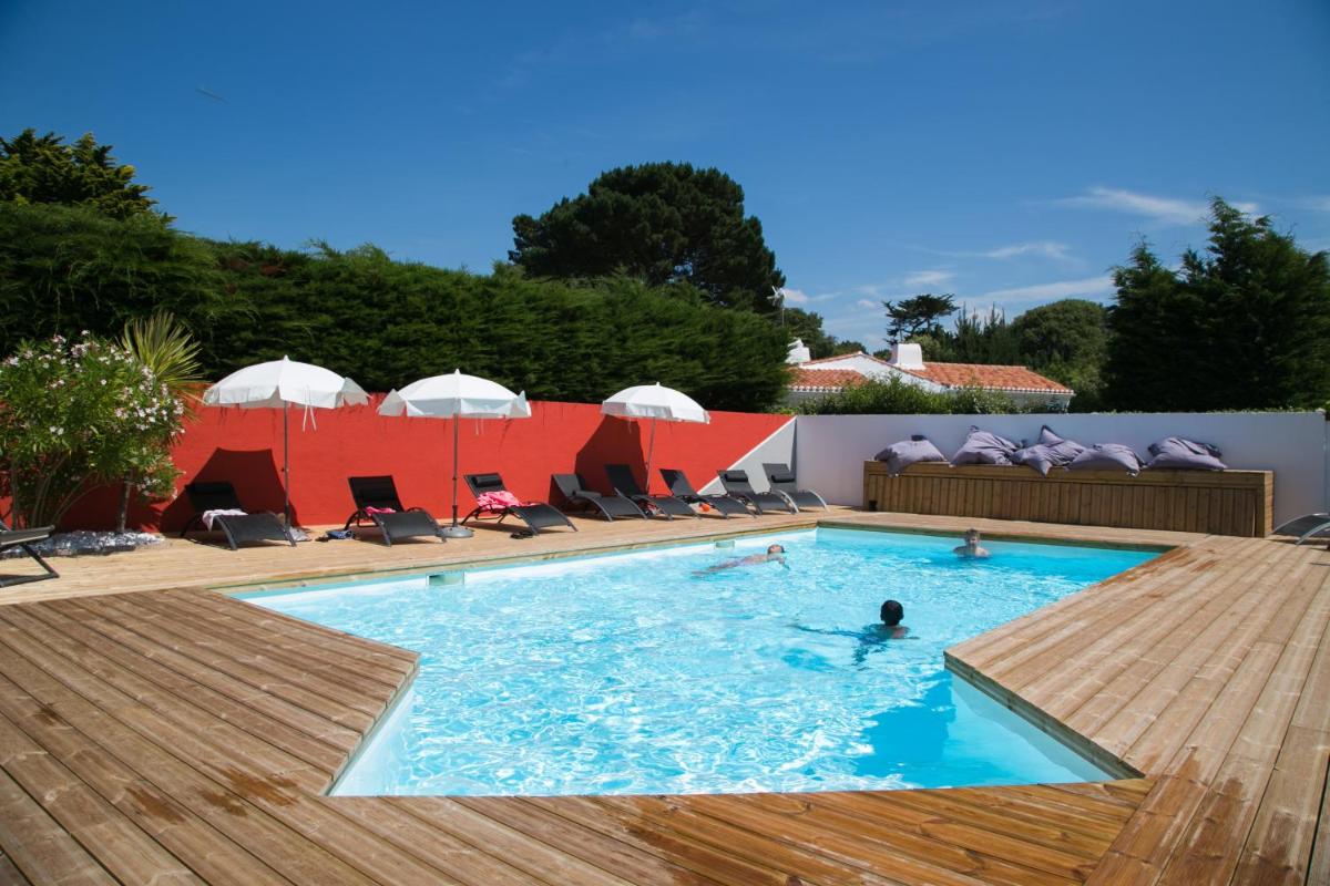 une personne nage dans une piscine dans l'établissement La Villa en L'île - 2 Piscines & Spa, à Noirmoutier-en-l'lle