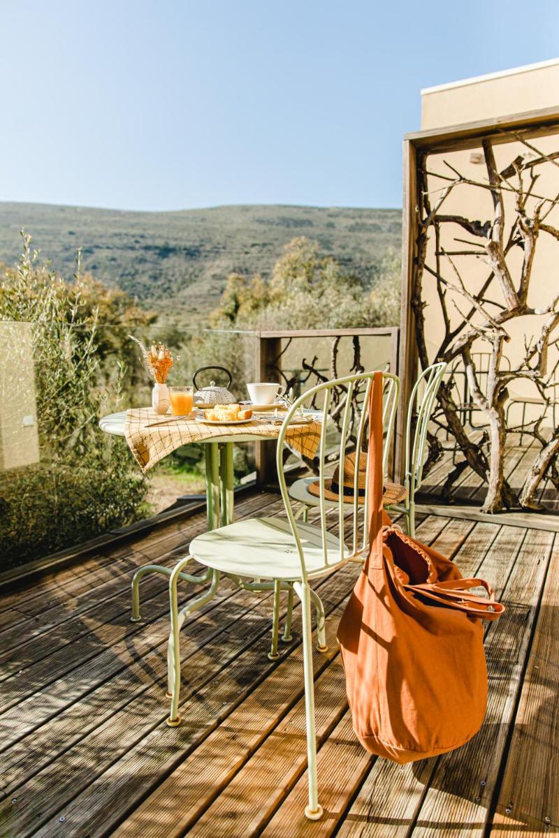 uma mesa e cadeiras num deque de madeira com vista em Cooking and Nature - Emotional Hotel em Alvados