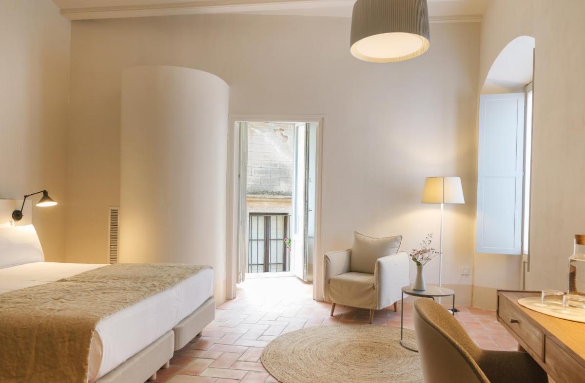 Un dormitorio con una cama y una silla y una ventana. en Can Mascort Eco Hotel, en Palafrugell