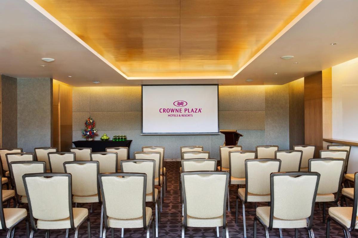a room with a bunch of chairs and a screen at Crowne Plaza Ahmedabad City Centre by IHG in Ahmedabad