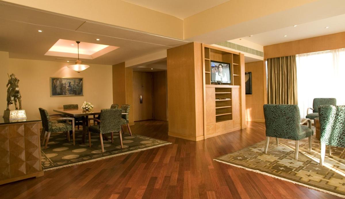 a dining room with a table and chairs at The Grand New Delhi in New Delhi a dining room with a table and chairs at The Grand New Delhi in New Delhi