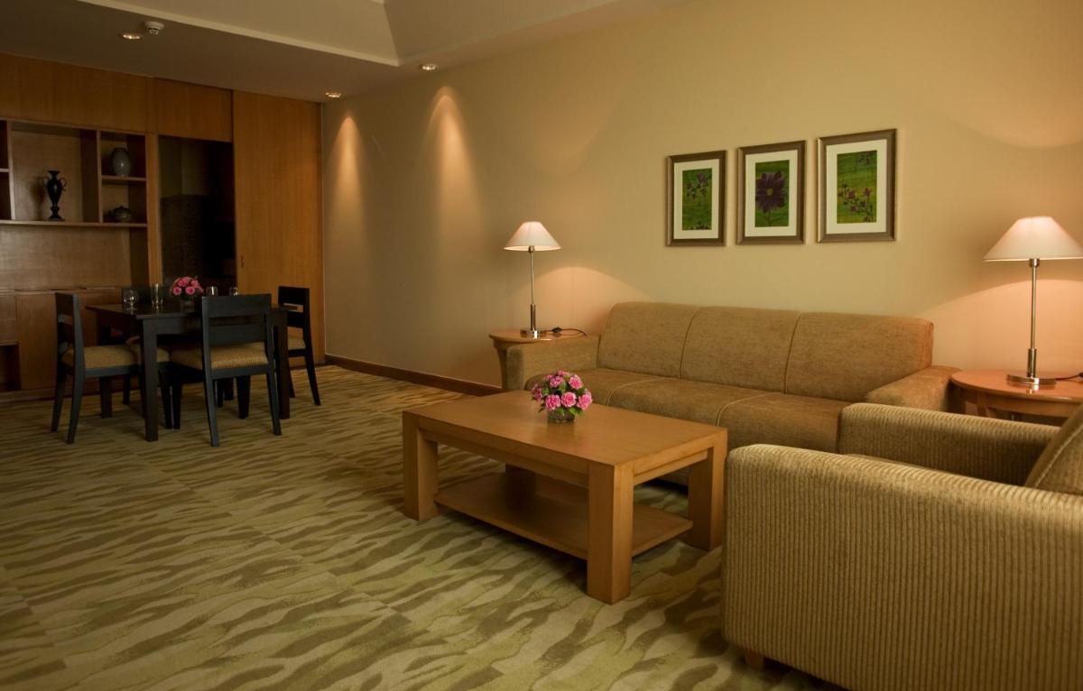 a living room with a couch and a table at The Grand New Delhi in New Delhi a living room with a couch and a table at The Grand New Delhi in New Delhi