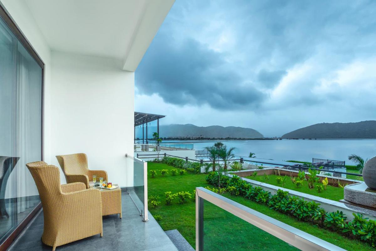 a balcony with a view of the water at ZANA Lakeview Resort - most scenic lakeside resort in Udaipur