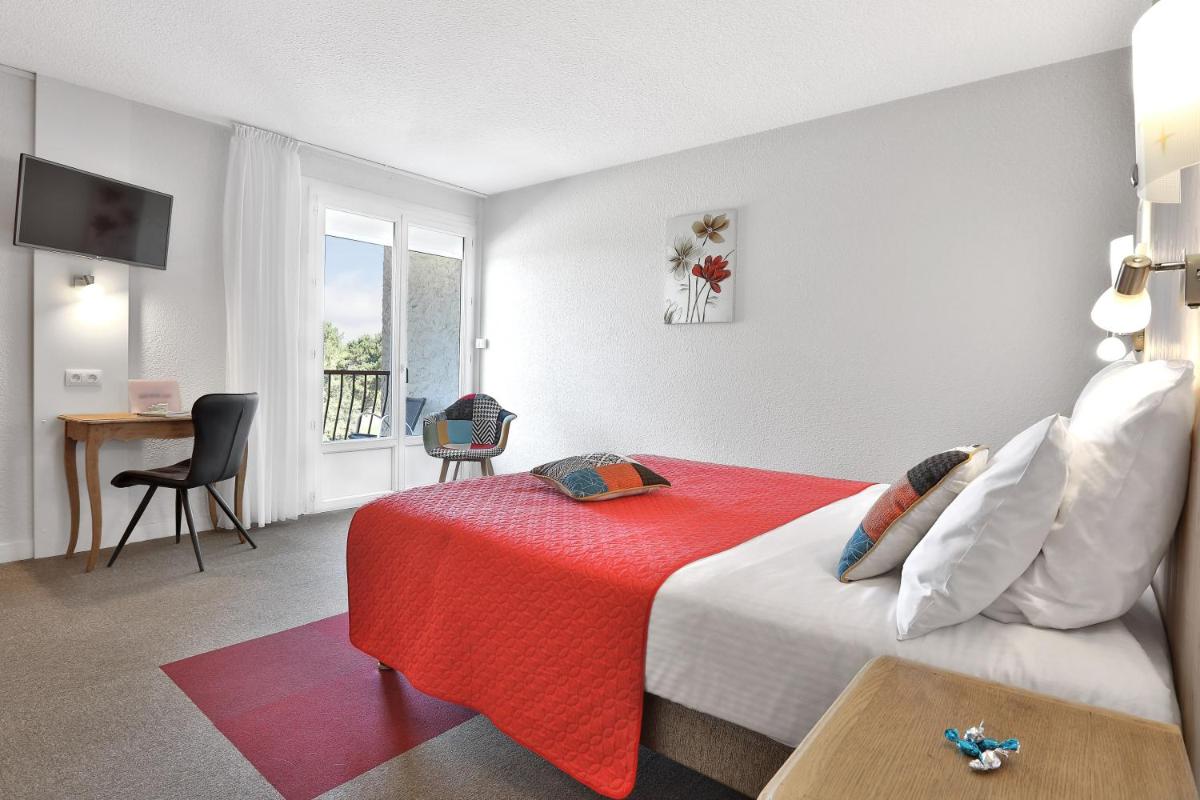 Un ou plusieurs lits dans un hébergement de l'établissement Logis Hotel Le Tropicana