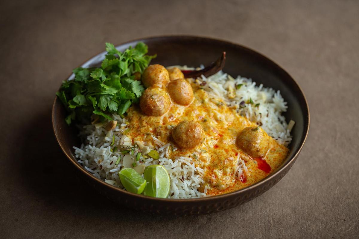 a bowl of rice with meatballs on top and greens at Hyatt Regency Jaipur Mansarovar in Jaipur a bowl of rice with meatballs on top and greens at Hyatt Regency Jaipur Mansarovar in Jaipur