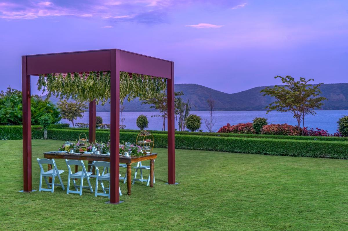 a table with chairs and a purple gazebo at ZANA Lakeview Resort - most scenic lakeside resort in Udaipur